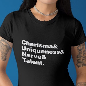 May include: Black t-shirt with white text that reads "Charisma & Uniqueness & Nerve & Talent."