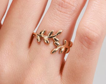 Könnte beinhalten: Goldring mit einem zarten Blattdesign. Der Ring ist offen und verstellbar, um den meisten Fingergrößen zu passen.