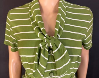 May include: Olive green and white striped dress with a matching belt. The dress features a unique neckline with a bow detail and button closure. The short-sleeved dress is displayed on a mannequin.