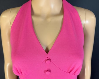 May include: A vibrant pink halter dress with a V-neckline and a series of matching buttons down the front. The dress has a fitted bodice and a classic, elegant design. The fabric appears to be a smooth, solid color, perfect for a special occasion.