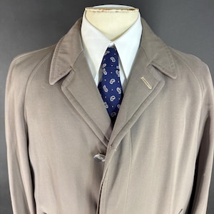 Puede incluir: Una taza de cerámica blanca con un asa negra y el texto "But First, Coffee" en negro, con una fuente de estilo manuscrito. La taza está sobre una superficie blanca.