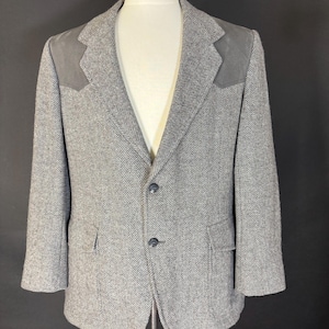 May include: A grey herringbone tweed blazer with suede elbow patches and a three-button closure.