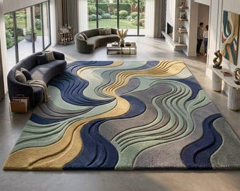 Op de afbeelding: Een rechthoekig vloerkleed met een getextureerd, driedimensionaal golfpatroon in tinten marineblauw, saliegroen, mosterdgeel en grijs. Het ontwerp bestaat uit vloeiende, verhoogde lijnen die een gelaagd, topografisch effect op het oppervlak creëren.