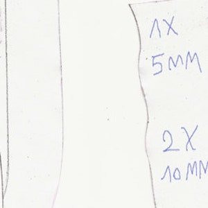 May include: A hand-drawn sketch of a knife blade and a label with measurements. The label indicates dimensions of 5mm and 10mm, with quantities of 1X and 2X. The knife blade is depicted in a simple, linear style.