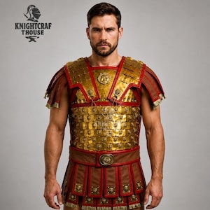 May include: A gold and red Roman-style cuirass with a brown leather skirt. The armor features intricate detailing, including rectangular plates and decorative elements. The Knightcrafthouse logo is visible in the upper left corner.