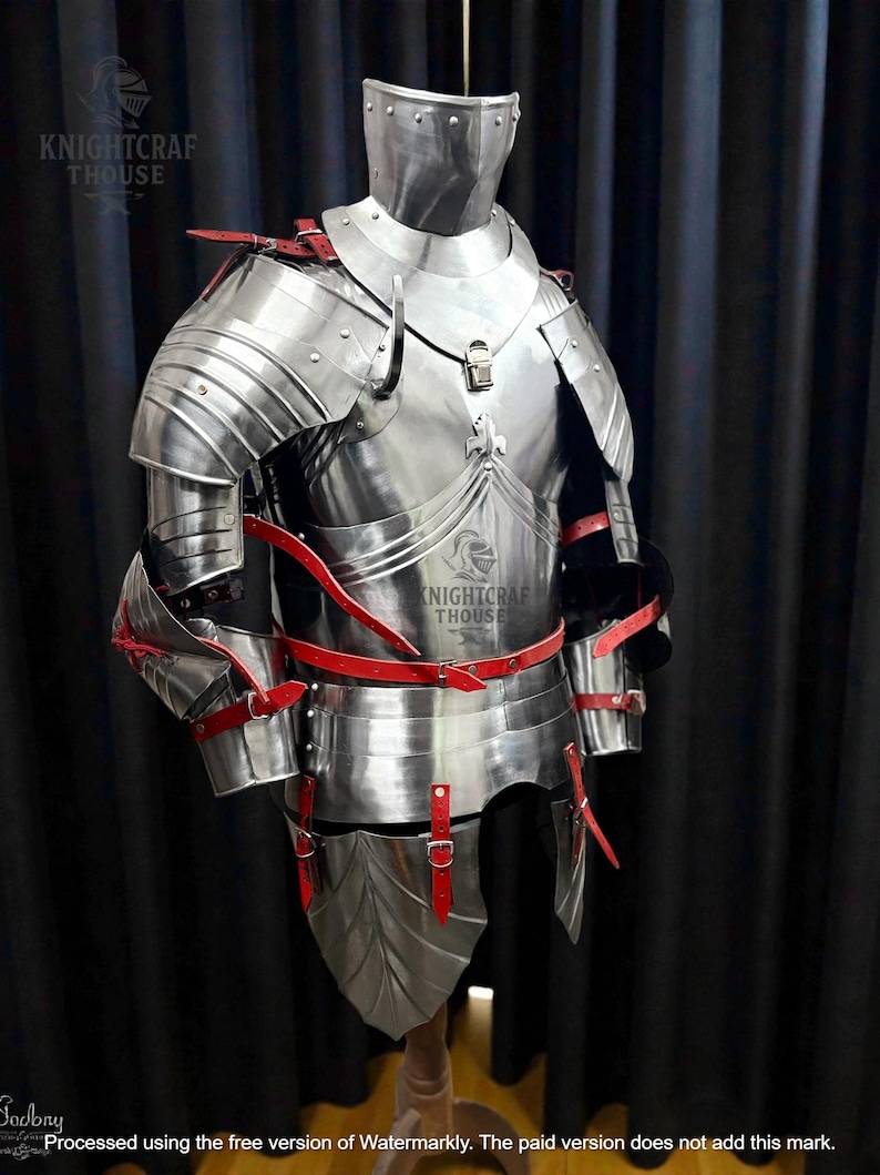 May include: A full suit of polished steel armor with red leather straps and accents. The armor includes a helmet, chest plate, shoulder guards, and leg protection. The Knightcrafthouse logo is visible.