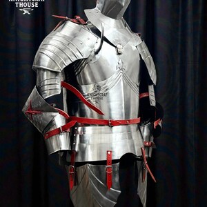 May include: A full suit of polished steel armor with red leather straps and accents. The armor includes a helmet, chest plate, shoulder guards, arm and leg protection. The image includes the text "KNIGHTCRAF THOUSE".
