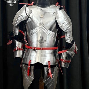 May include: A full suit of polished steel armor with red leather straps and accents. The armor includes a breastplate, shoulder guards, arm and leg protection. The text "KNIGHTCRAF THOUSE" is visible on the armor.