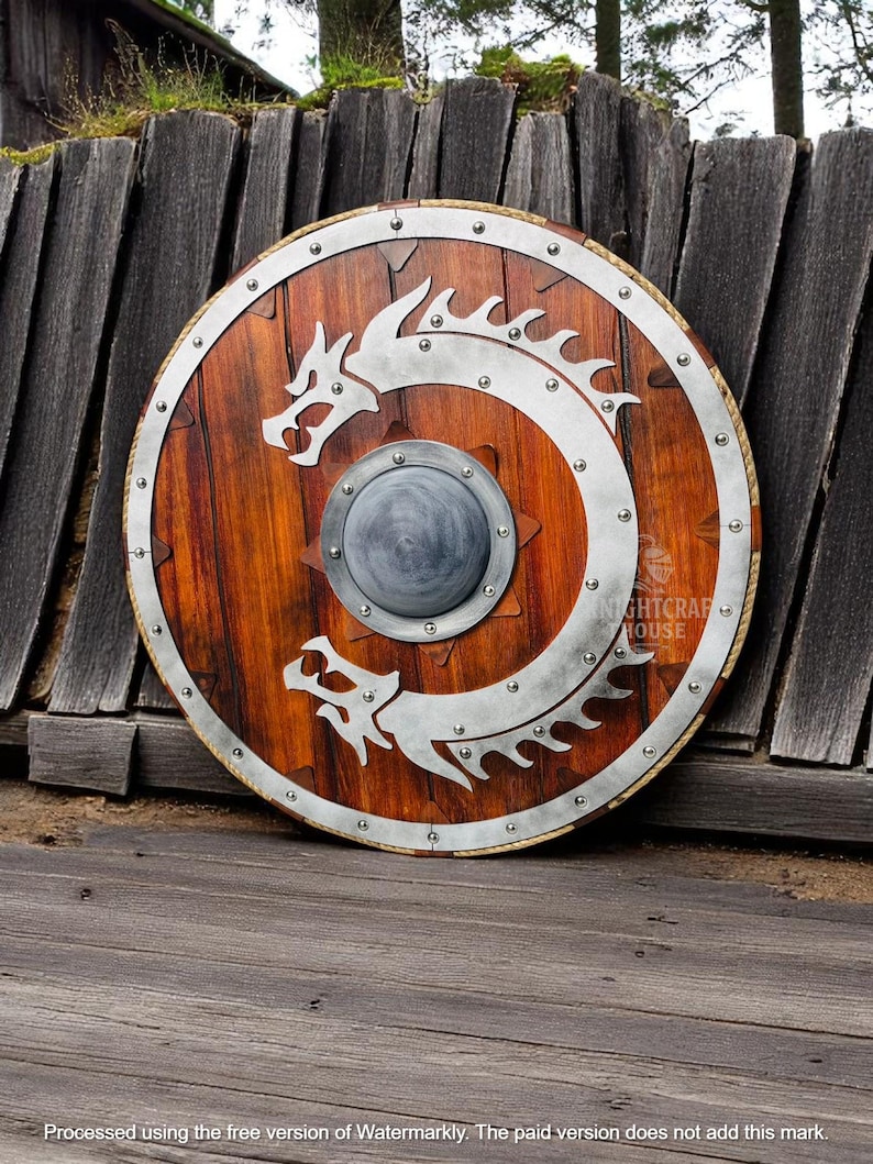 May include: A round wooden shield with a metal rim and two silver dragons on the front. The shield is decorated with metal rivets and has a small round metal boss in the center.