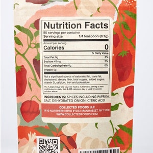 May include: Spice packet with a colorful floral design featuring red peppers and garlic. The label displays nutrition facts, including ingredients like paprika and dehydrated onion. The serving size is 1/4 teaspoon (0.7g).