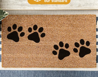 May include: Brown coir doormat with four black paw prints. The text "Treated With DURAPRINT® Technology" is printed on the bottom of the mat.