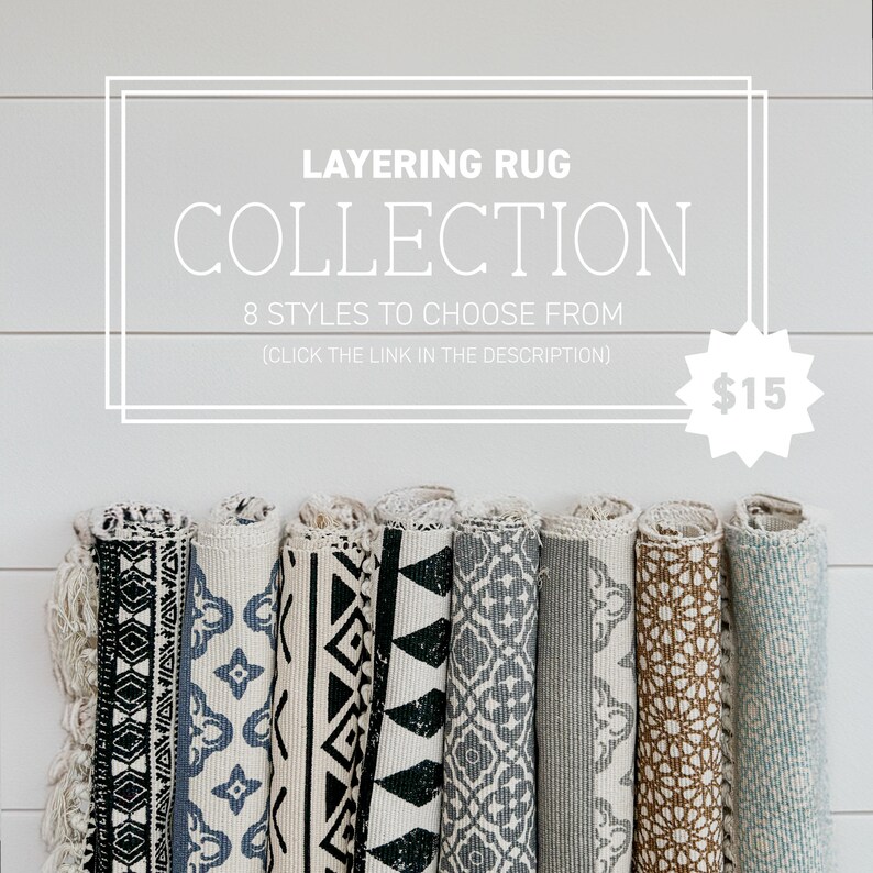 Op de afbeelding: Een verzameling van acht opgerolde tapijten met verschillende geometrische patronen in zwart, wit en blauw. De tapijten worden getoond tegen een witte houten achtergrond. De tekst "LAYERING RUG COLLECTION 8 STYLES TO CHOOSE FROM (CLICK THE LINK IN THE DESCRIPTION) $15" wordt boven de tapijten weergegeven.