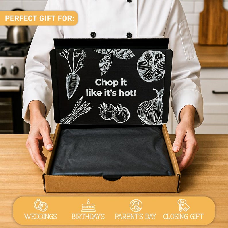 Puede incluir: Una caja de regalo de cart&oacute;n con interior negro y tapa negra con ilustraciones blancas de verduras y el texto "Chop it like it's hot!". La caja est&aacute; abierta, revelando papel de seda negro. Las palabras "Perfect Gift For" est&aacute;n en la parte superior.