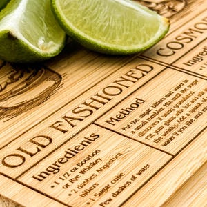 a close up of a cutting board with limes on it
