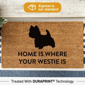 Może przedstawiać: Brązowa mata kokosowa z napisem "Home is where your Westie is" i czarną sylwetką psa rasy Westie. Mata jest zabezpieczona technologią Duraprint.