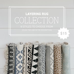 Puede incluir: Una colecci&oacute;n de ocho alfombras enrolladas con varios patrones geom&eacute;tricos en negro, blanco y azul. Las alfombras se muestran sobre un fondo de madera blanca. El texto "LAYERING RUG COLLECTION 8 STYLES TO CHOOSE FROM (CLICK THE LINK IN THE DESCRIPTION) $15" se muestra sobre las alfombras.