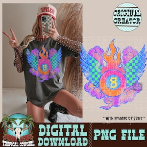 Könnte beinhalten: Dunkelgraues T-Shirt mit einer farbenfrohen Grafik einer brennenden Achtkugel mit Flügeln. Das Design umfasst orangefarbene Flammen, blau-grün karierte Flügel und die Zahl 8. Der Text "DIGITAL PNG FILE DOWNLOAD" ist ebenfalls sichtbar.