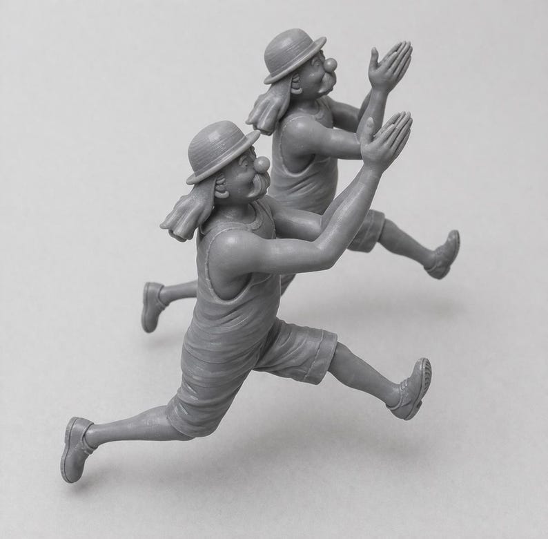 May include: Two gray figurines of clowns in mid-air, with arms raised and legs extended as if running. Each clown wears a hat, shorts, and a tank top. They have large red noses and exaggerated facial features.
