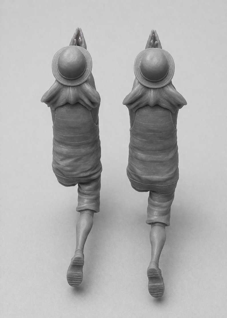 May include: Two gray figurines of a person in a straw hat, shirt, and shorts, with hands clasped in prayer. The figures are in a walking pose, with one leg bent. The hat has a round top and a wide brim.