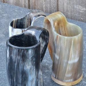 Peut inclure: Trois cornes &agrave; boire en corne polie avec des bases en bois. Les cornes sont de diff&eacute;rentes nuances de brun, noir et blanc.