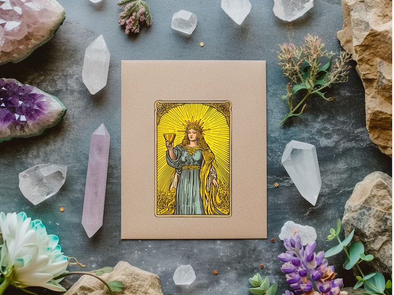May include: A tarot card with a gold frame and a woman holding a golden chalice. The woman is wearing a blue robe and a crown. The background is yellow with a sunburst design.
