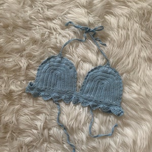 May include: A light blue crocheted halter top with a scalloped edge.