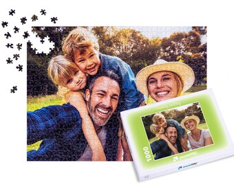 Può includere: Un puzzle da 1000 pezzi con una famiglia di quattro persone che sorridono e si godono una giornata all'aperto. La scatola del puzzle ha uno sfondo verde con il testo "Gita in famiglia" e il marchio del puzzle "puzzleYOU".