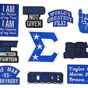 May include: A collection of embroidered patches in blue and white, featuring various phrases and symbols. The patches include text like "I AM the Master of my Fate," "EARNED NOT GIVEN," and "WORLD'S GREATEST FRAT."