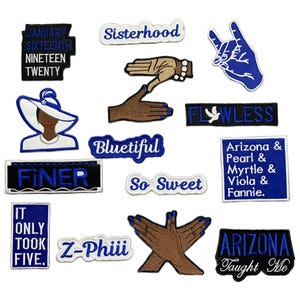 May include: A collection of embroidered patches in various shapes and sizes. The patches feature text like "Sisterhood", "Bluetiful", and "Finer", along with images of hands and a woman in a hat. The color scheme is primarily blue, white, and brown.