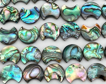 May include: A strand of iridescent abalone shell beads, each bead is a half-circle shape with a smooth, polished surface. The beads are arranged in rows, showing the natural variations in color and pattern of the abalone shell.