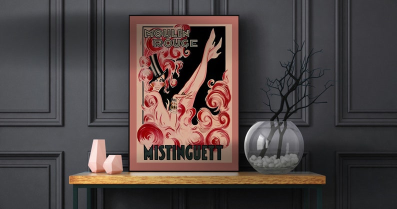 May include: A vintage poster advertising the Moulin Rouge featuring a woman in a black top hat and red and pink swirls. The text on the poster reads "Moulin Rouge" and "Mistinguett".