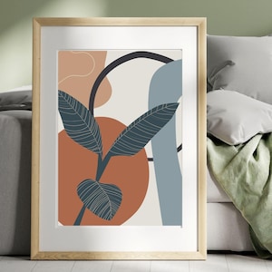 Op de afbeelding: Een ingelijste abstracte kunstprint met een lichtbruine lijst. De print toont een gestileerd blad met een donkerblauw en groen kleurenschema tegen een achtergrond van abstracte vormen in tinten oranje, blauw en beige.