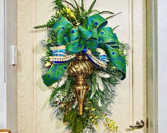 Guirnalda navideña de pavo real: corona navideña verde y azul en forma de lágrima con adorno dorado y elegante cinta de pavo real para la puerta principal.