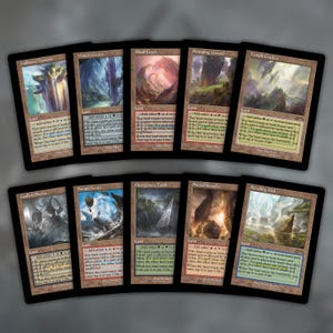 Puede incluir: Una colección de diez cartas de tierra de Magic: The Gathering dispuestas en dos filas. Cada carta presenta una ilustración de paisaje fantástico única, un borde negro y texto que detalla los tipos de tierra y mecánicas de juego.