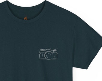 May include: A dark blue t-shirt with a white outline of a camera on the left chest.