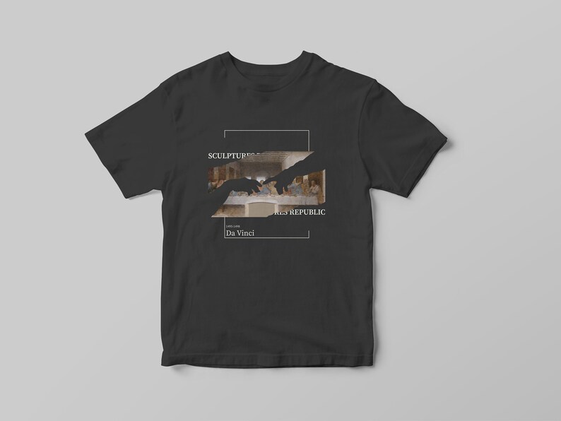 Puede incluir: Camiseta negra con un gr&aacute;fico blanco de dos manos que se alcanzan la una a la otra. El gr&aacute;fico es una imagen recortada de La &Uacute;ltima Cena de Leonardo da Vinci. El texto "SCULPTURE" y "THE REPUBLIC" est&aacute; por encima de la imagen y "Da Vinci" est&aacute; por debajo de la imagen.