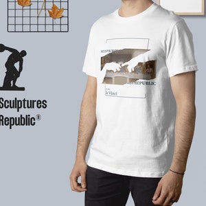 Puede incluir: Camiseta blanca con un gr&aacute;fico de la Creaci&oacute;n de Ad&aacute;n de Miguel &Aacute;ngel, con el texto "Sculptures Republic" y "da Vinci" en el gr&aacute;fico.