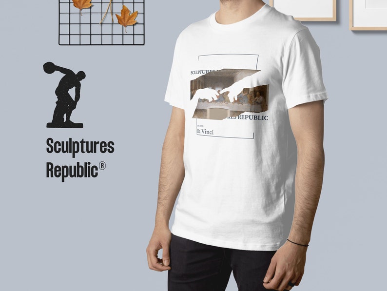 Puede incluir: Camiseta blanca con un gr&aacute;fico de la Creaci&oacute;n de Ad&aacute;n de Miguel &Aacute;ngel, con el texto "Sculptures Republic" y "da Vinci" en el gr&aacute;fico.