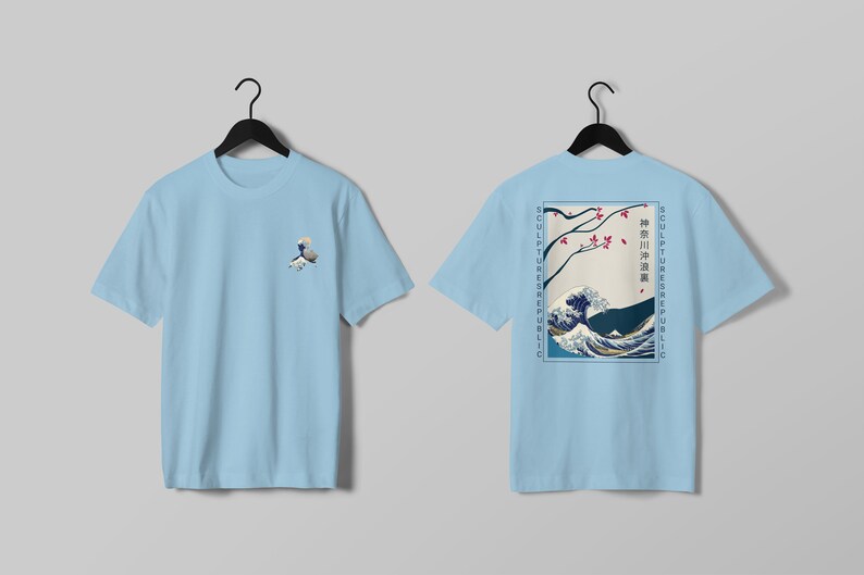 K&ouml;nnte beinhalten: Hellblaue T-Shirts mit japanischem Wellenmuster. Eines zeigt eine kleine Wellengrafik. Das andere zeigt eine gr&ouml;&szlig;ere Wellenszene mit japanischem Text und den Worten "SCULPTURE REPUBLIC" vertikal an den Seiten.