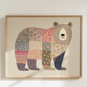 May include: A framed art print featuring a bear illustration. The bear's body is composed of patchwork patterns in various colors and floral designs. The bear has a brown head and a beige background. The frame is made of light-colored wood.