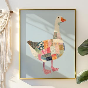 May include: Framed artwork featuring a goose with a patchwork design in various colors, including pink, orange, blue, and green. The goose has a white head and neck, an orange beak, and pink feet. The artwork is set against a light blue background.