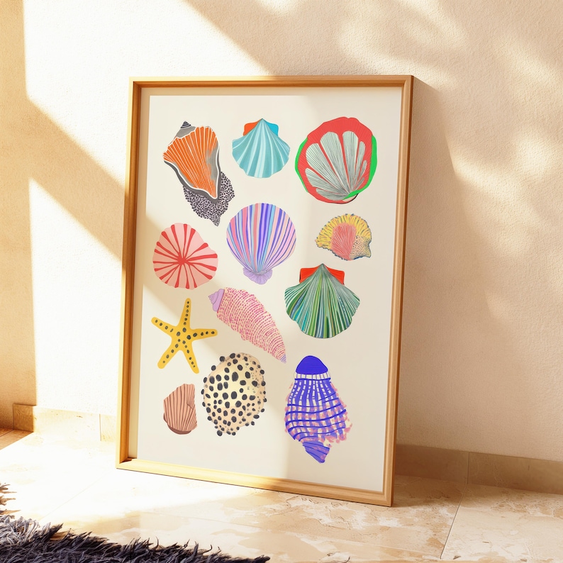 Puede incluir: Una impresi&oacute;n art&iacute;stica enmarcada con ilustraciones coloridas de varias conchas marinas y una estrella de mar. La obra de arte incluye conchas en tonos naranja, azul, rojo, rosa, amarillo y verde, sobre un fondo crema. El marco es de madera marr&oacute;n claro.