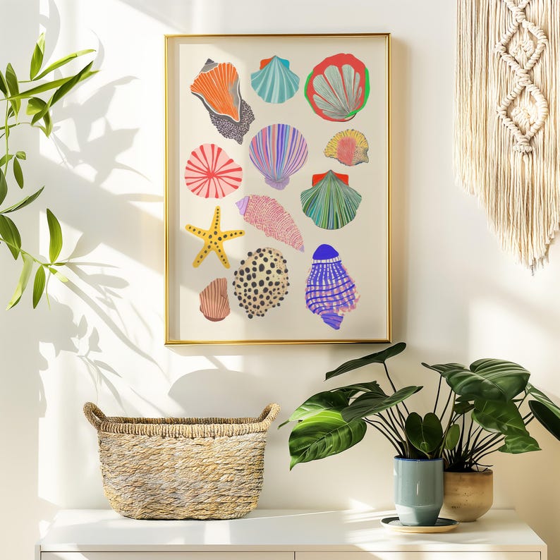 Puede incluir: Una impresi&oacute;n art&iacute;stica enmarcada con ilustraciones coloridas de varias conchas marinas y una estrella de mar. La obra de arte incluye conchas en tonos naranja, azul, rosa y verde, sobre un fondo crema. El marco es dorado y la impresi&oacute;n se muestra sobre una superficie blanca.