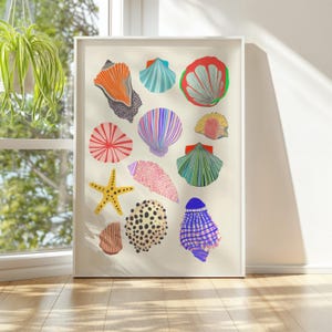 Puede incluir: Una impresi&oacute;n art&iacute;stica enmarcada con ilustraciones coloridas de varias conchas marinas. La obra de arte incluye una estrella de mar y varias conchas en tonos naranja, azul, rosa y amarillo, sobre un fondo crema. La impresi&oacute;n est&aacute; enmarcada en blanco.