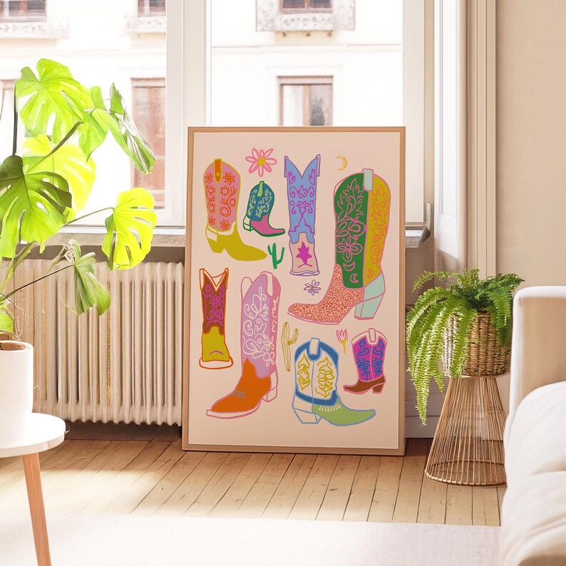 May include: A colorful print featuring a collection of cowboy boots in various styles and colors. The boots are decorated with floral patterns, stars, and other designs. The print is set against a light pink background.