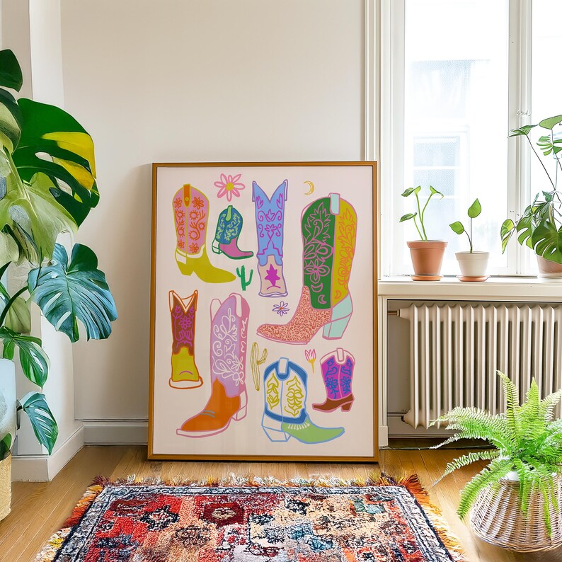 May include: A colorful illustration of cowboy boots in various styles and colors. The boots are arranged in a random pattern on a white background. The illustration is framed in a wooden frame.