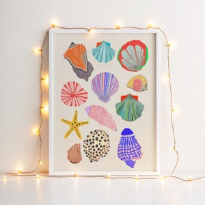 Puede incluir: Una impresi&oacute;n enmarcada con ilustraciones coloridas de varias conchas marinas y una estrella de mar. La obra de arte incluye conchas en tonos naranja, azul, rojo, rosa y amarillo, con un marco blanco. Una cadena de luces blancas c&aacute;lidas est&aacute; colgada alrededor del marco.
