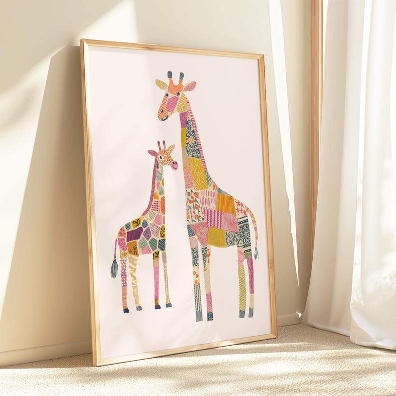 May include: A framed art print featuring two giraffes with patchwork patterns in various colors. The giraffes are standing on a white background, and the frame is a light wood color. The artwork is leaning against a wall.