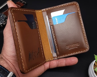 May include: A brown leather wallet with a stitched edge and a card slot on the outside. The wallet is open to reveal a card slot on the inside and the text "BRIARROSE LEATHER CO."