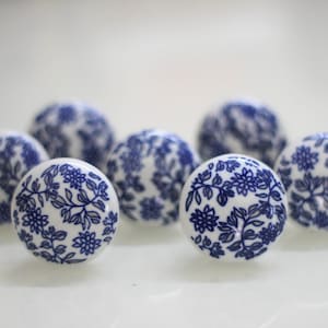 May include: Set of seven white ceramic drawer knobs with a blue floral pattern.
